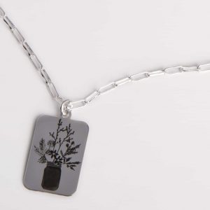 Collar de plata con cadena de eslabones rectangulares y con medalla rectangular grabada con un motivo botánico.